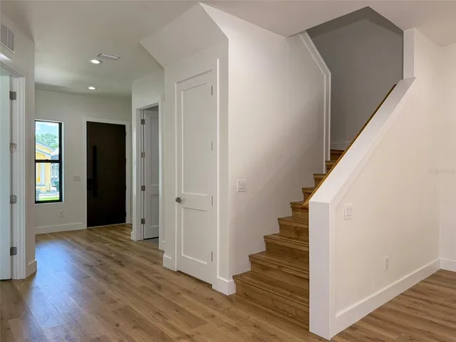 a view of a room that has a window and wooden floor