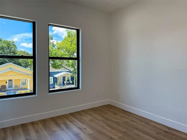 an empty room with wooden floor & closet area