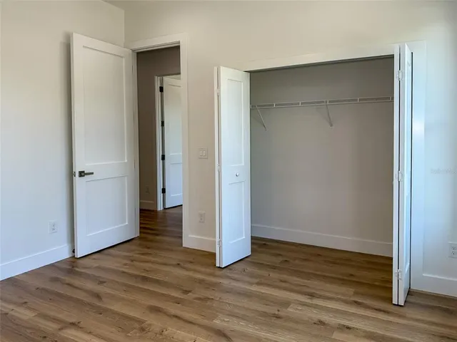a view of empty room with wooden floor