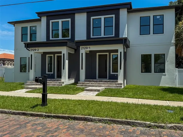 a view of a brick house with front yard