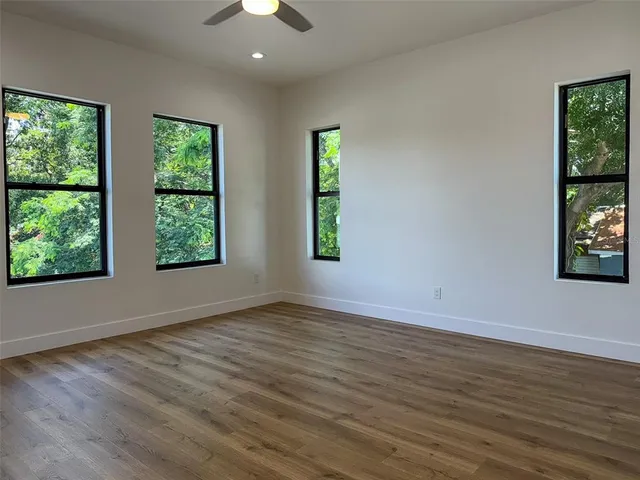 an empty room with wooden floor and a window
