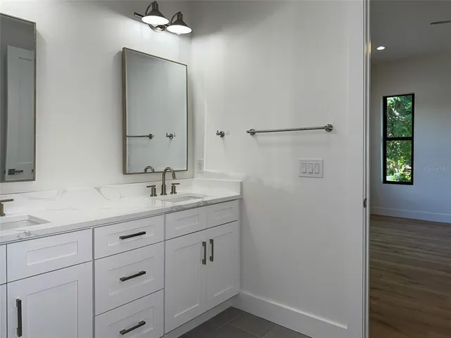 a bathroom with a double vanity sink mirror and shower
