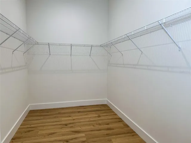 a view of a hallway with wooden floor and closet