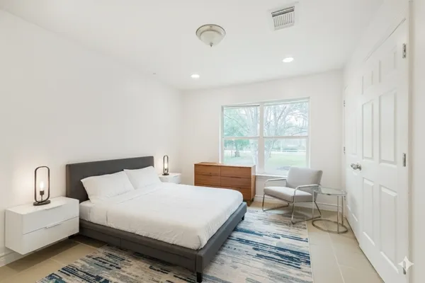 a bedroom with a large bed and a window