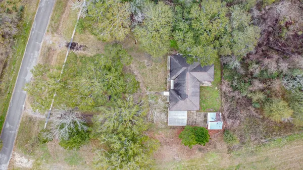 a aerial view of a house with a yard and large trees