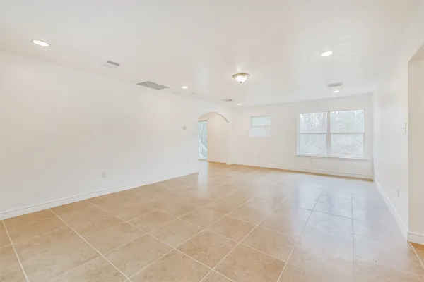 an empty room with white walls and windows