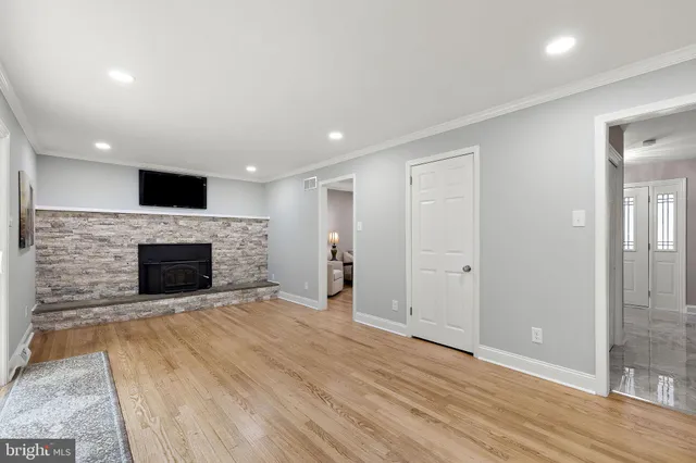 an empty room with wooden floor and fireplace
