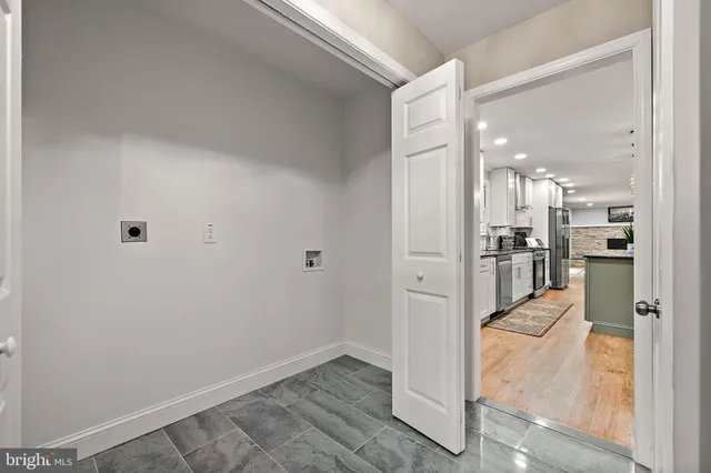 a view of a hallway with wooden floor and a kitchen