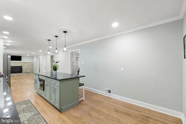 a kitchen with stainless steel appliances granite countertop a sink and a stove with wooden floor