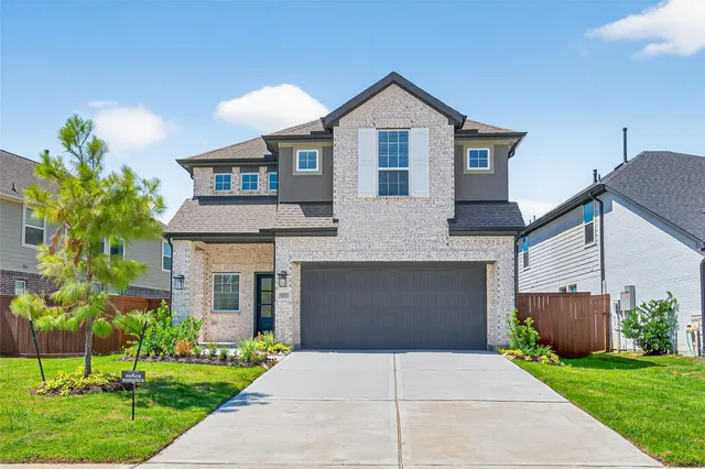 a front view of a house with a yard and a garage