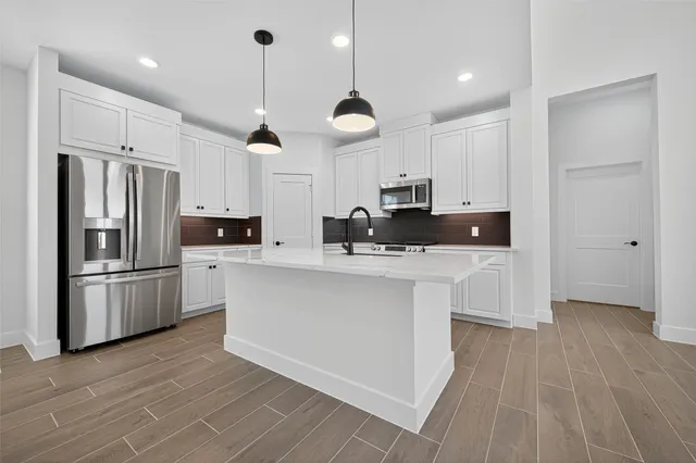 a kitchen with kitchen island a sink stainless steel appliances and cabinets
