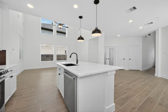 a kitchen with stainless steel appliances granite countertop a sink a stove and a wooden floors