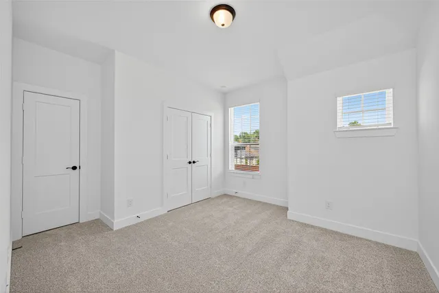 an empty room with windows and closet