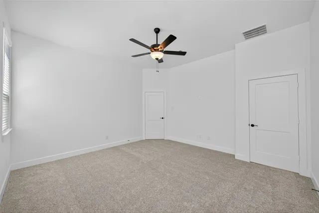 an empty room with a window and a ceiling fan
