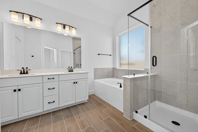 a spacious bathroom with double sink a large mirror and shower