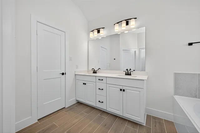 a spacious bathroom with a double vanity sink a mirror and a shower