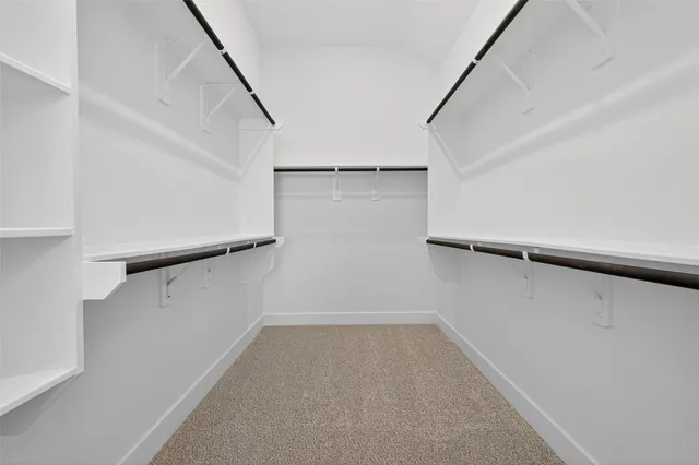 a view of walk in closet with empty racks