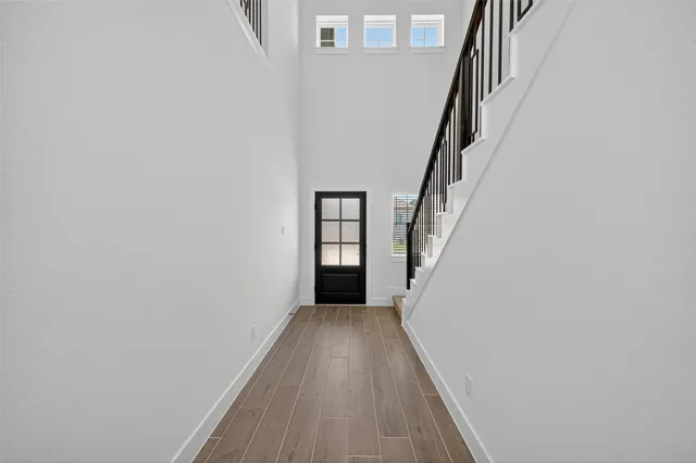 a view of a hallway with wooden floor and entryway