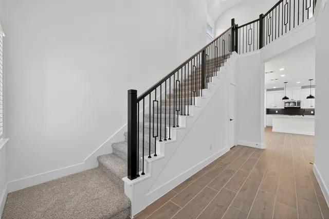 a view of a hallway with wooden floor and staircase