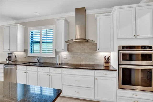 a kitchen with white cabinets and appliances