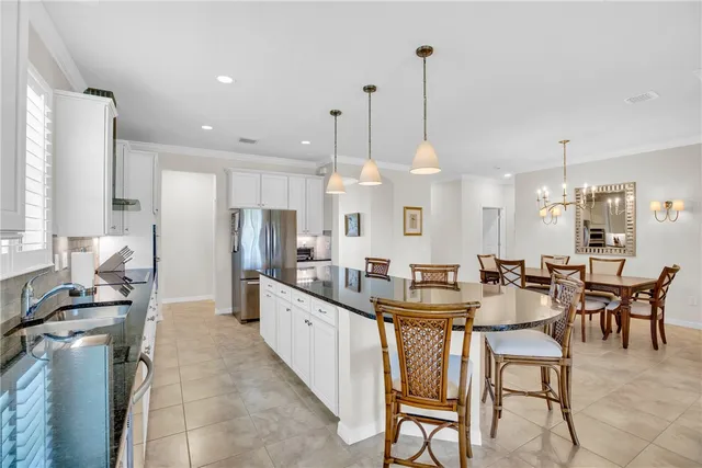 a large kitchen with kitchen island a large counter top space a sink and stainless steel appliances