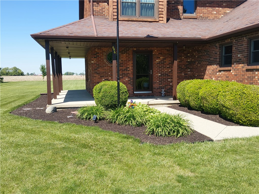 646 North Rangeline Road Pleasant Hill, OH 45359 - Photo 3 of 11 A classic brick-clad residence welcomes with a covered porch and manicured landscaping.