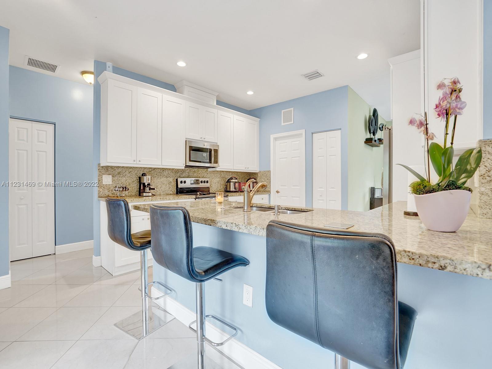 17335 Southwest 298th Street Homestead, FL 33030 - Photo 12 of 32 a kitchen with kitchen island granite countertop a counter space a sink appliances and cabinets