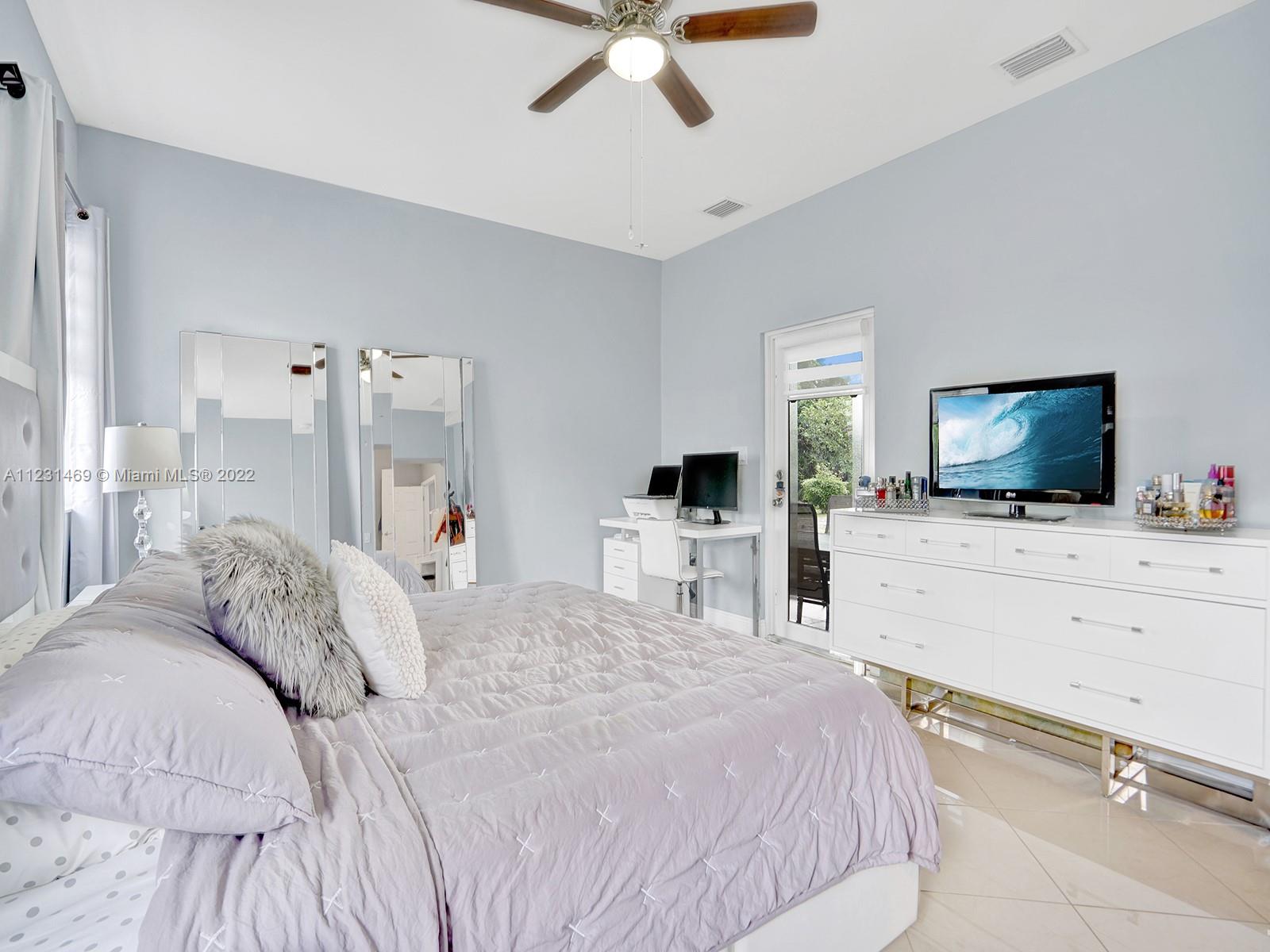 17335 Southwest 298th Street Homestead, FL 33030 - Photo 19 of 32 a bedroom with a bed and a flat screen tv