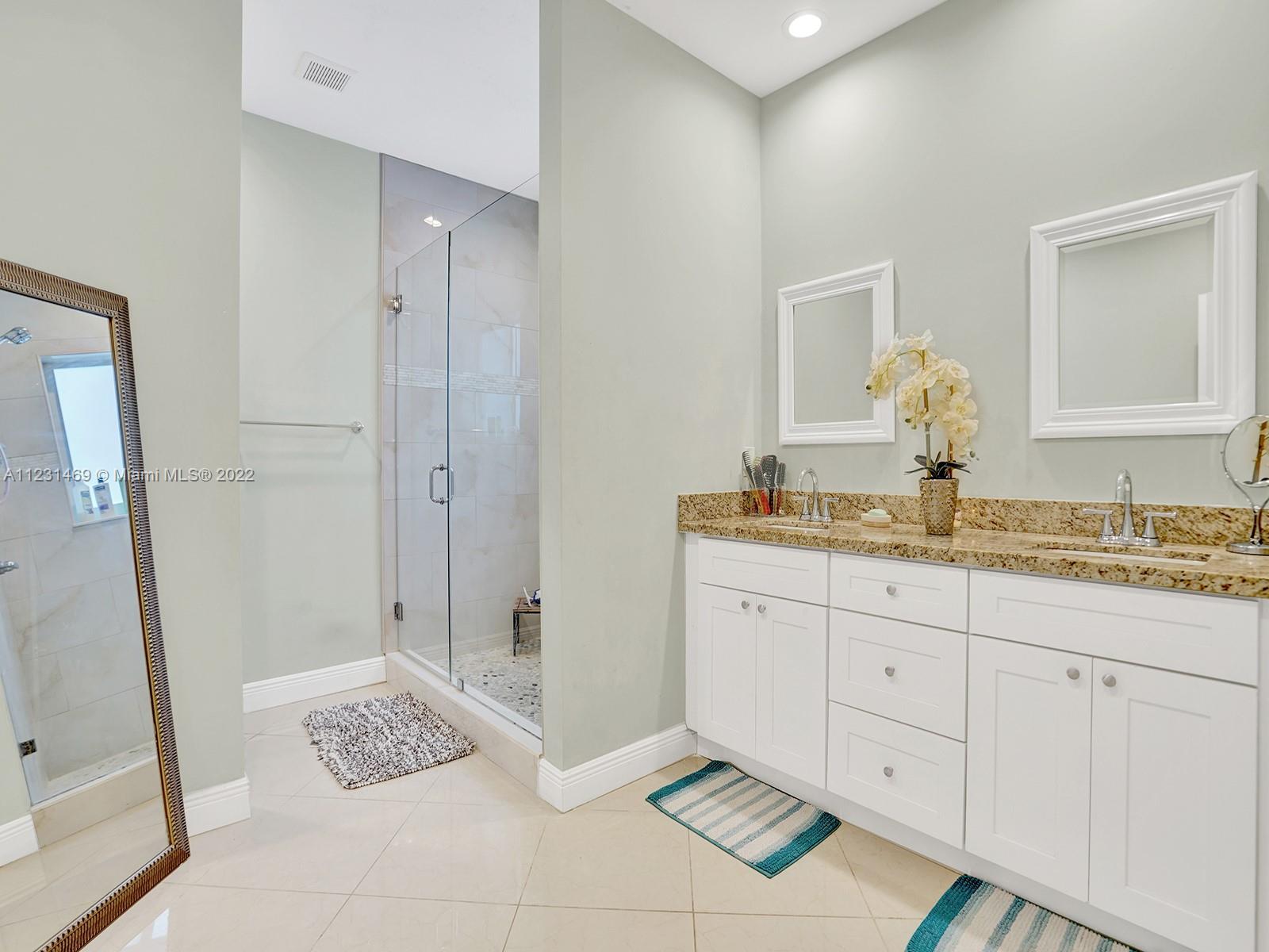 17335 Southwest 298th Street Homestead, FL 33030 - Photo 22 of 32 a bathroom with a granite countertop sink a mirror and shower