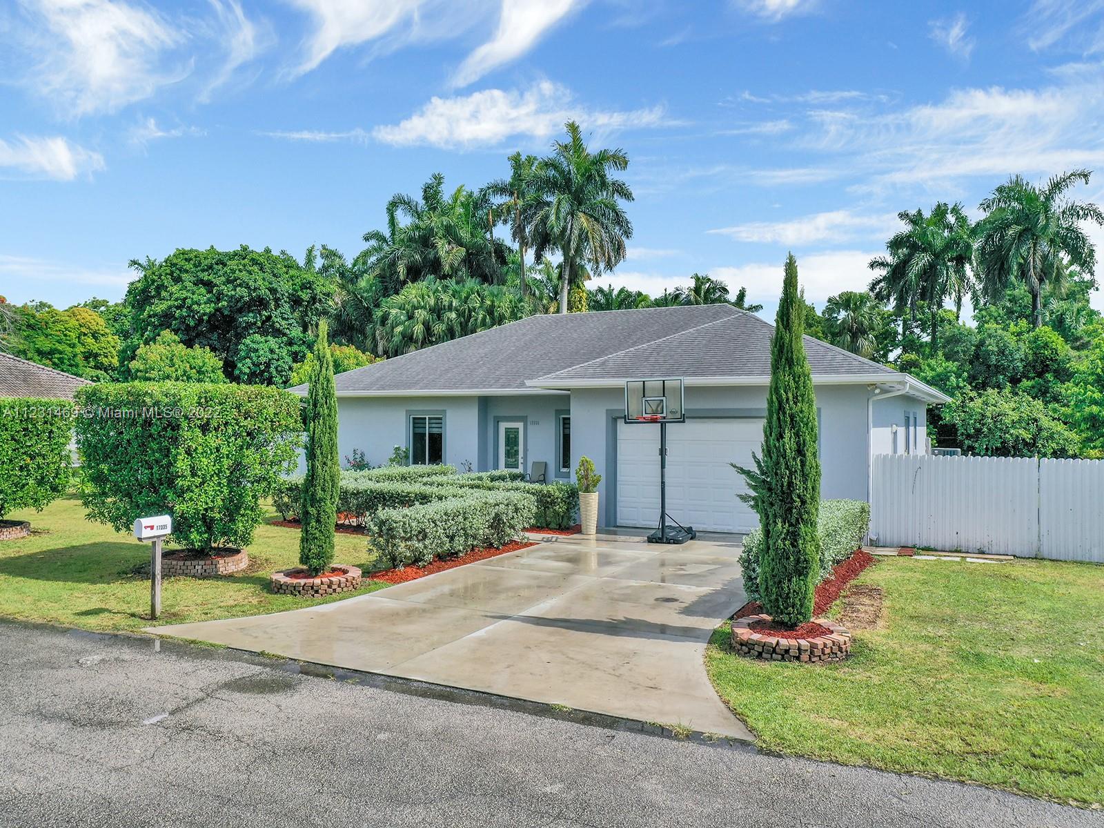 17335 Southwest 298th Street Homestead, FL 33030 - Photo 6 of 32 a front view of a house with a yard and potted plants