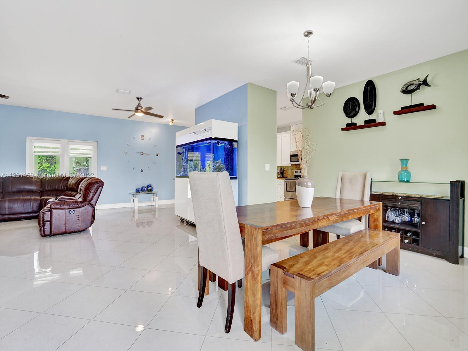 17335 Southwest 298th Street Homestead, FL 33030 - Photo 7 of 32 a living room with furniture kitchen view and a chandelier