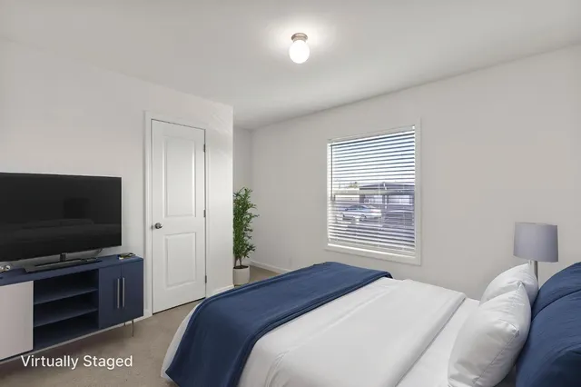 a bedroom with a bed and a flat screen tv