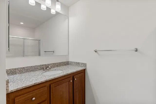 a bathroom with a granite countertop sink and a mirror