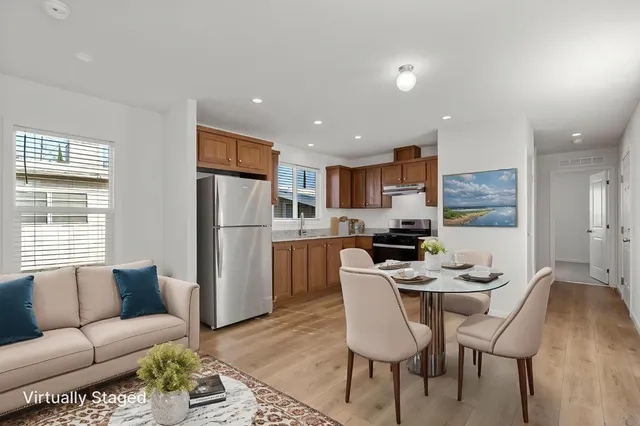 a living room with stainless steel appliances kitchen island furniture and a window