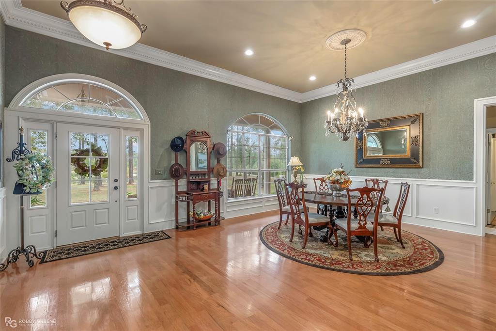 400 Crouch Road Benton, LA 71006 - Photo 9 of 40 a view of a dining room with furniture a chandelier and wooden floor