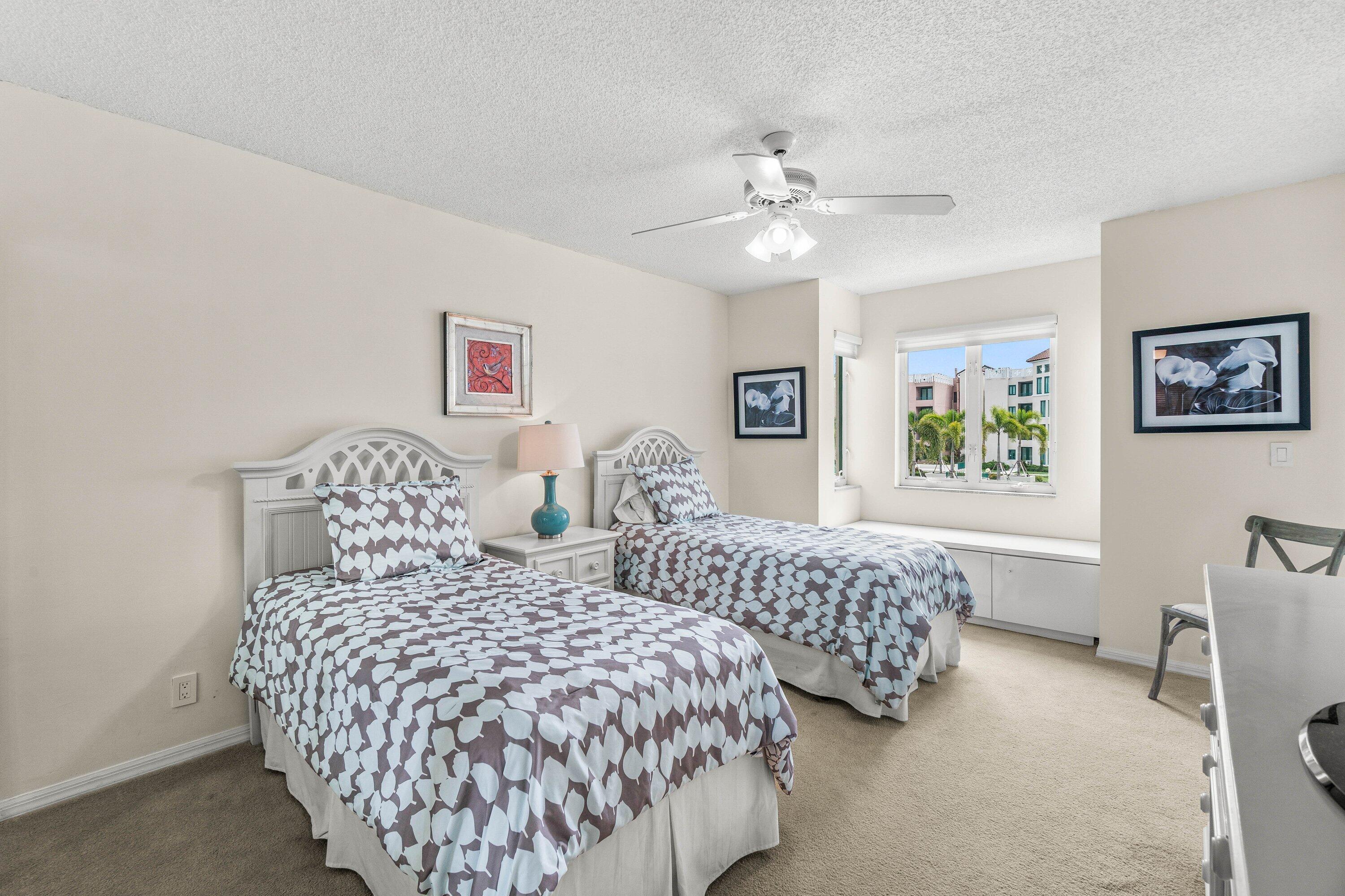 100 Southeast 5th Avenue, Unit 311 Boca Raton, FL 33432 - Photo 20 of 57 a bedroom with two beds and a chandelier