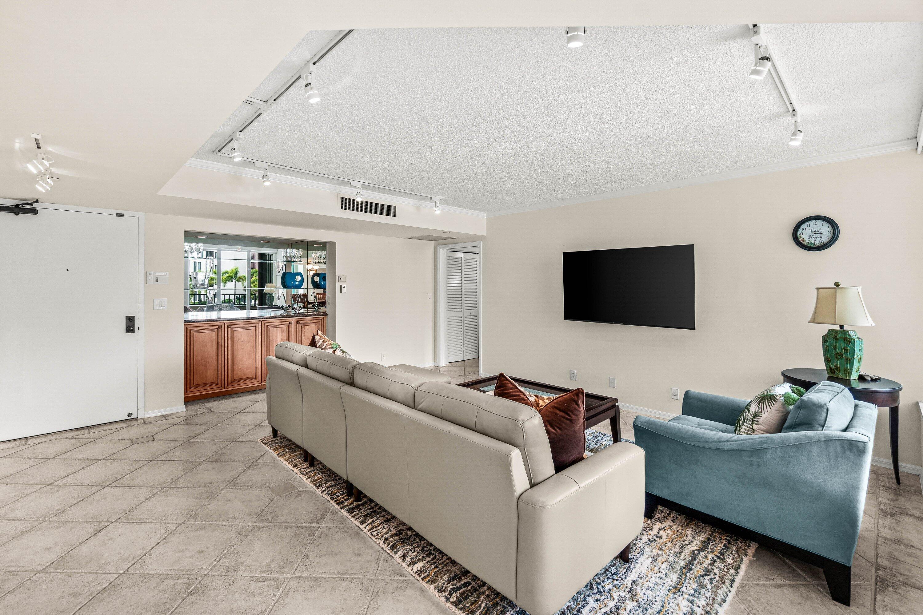 100 Southeast 5th Avenue, Unit 311 Boca Raton, FL 33432 - Photo 3 of 57 a living room with furniture and a flat screen tv