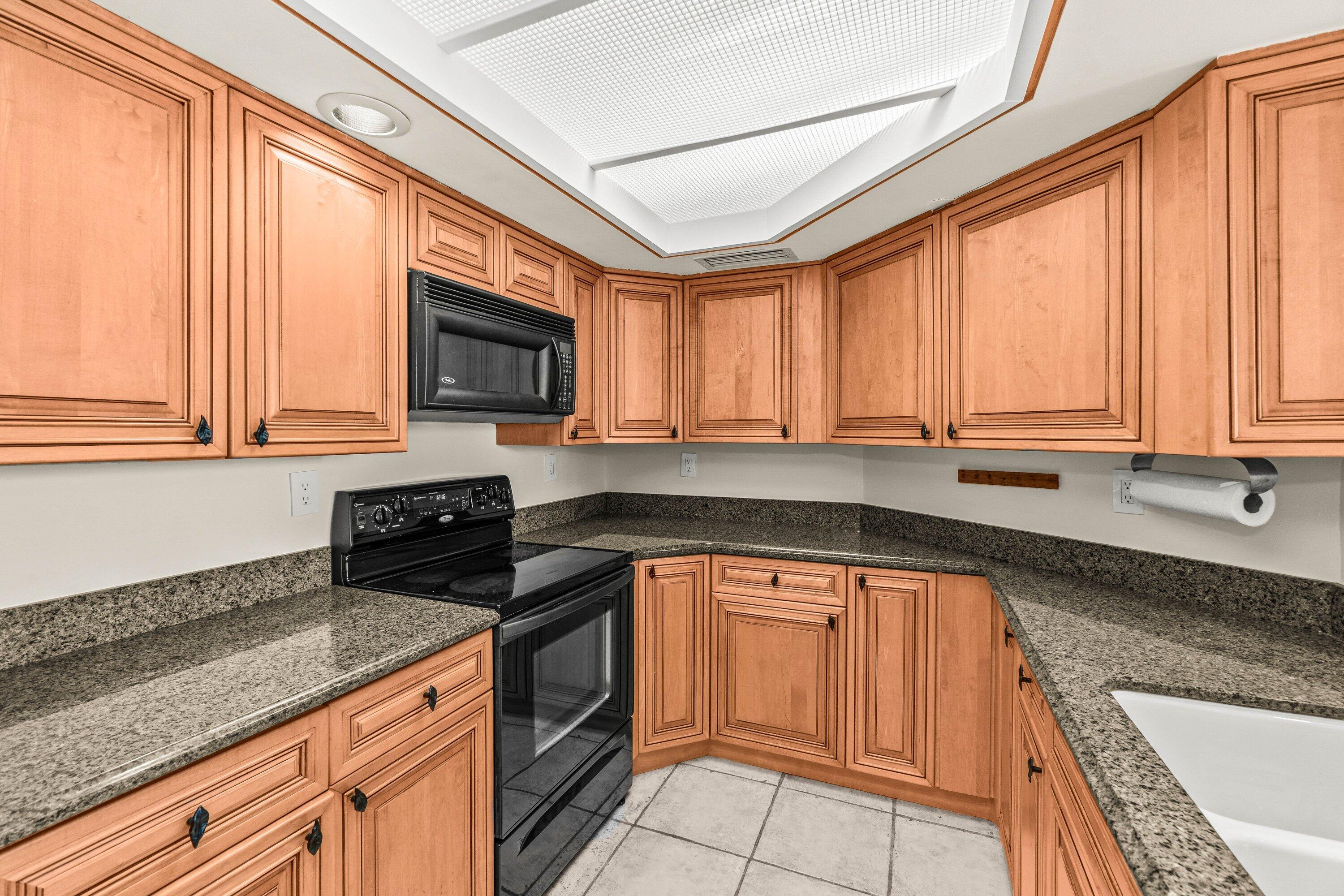 100 Southeast 5th Avenue, Unit 311 Boca Raton, FL 33432 - Photo 9 of 57 a kitchen with granite countertop a sink a window stainless steel appliances and cabinets