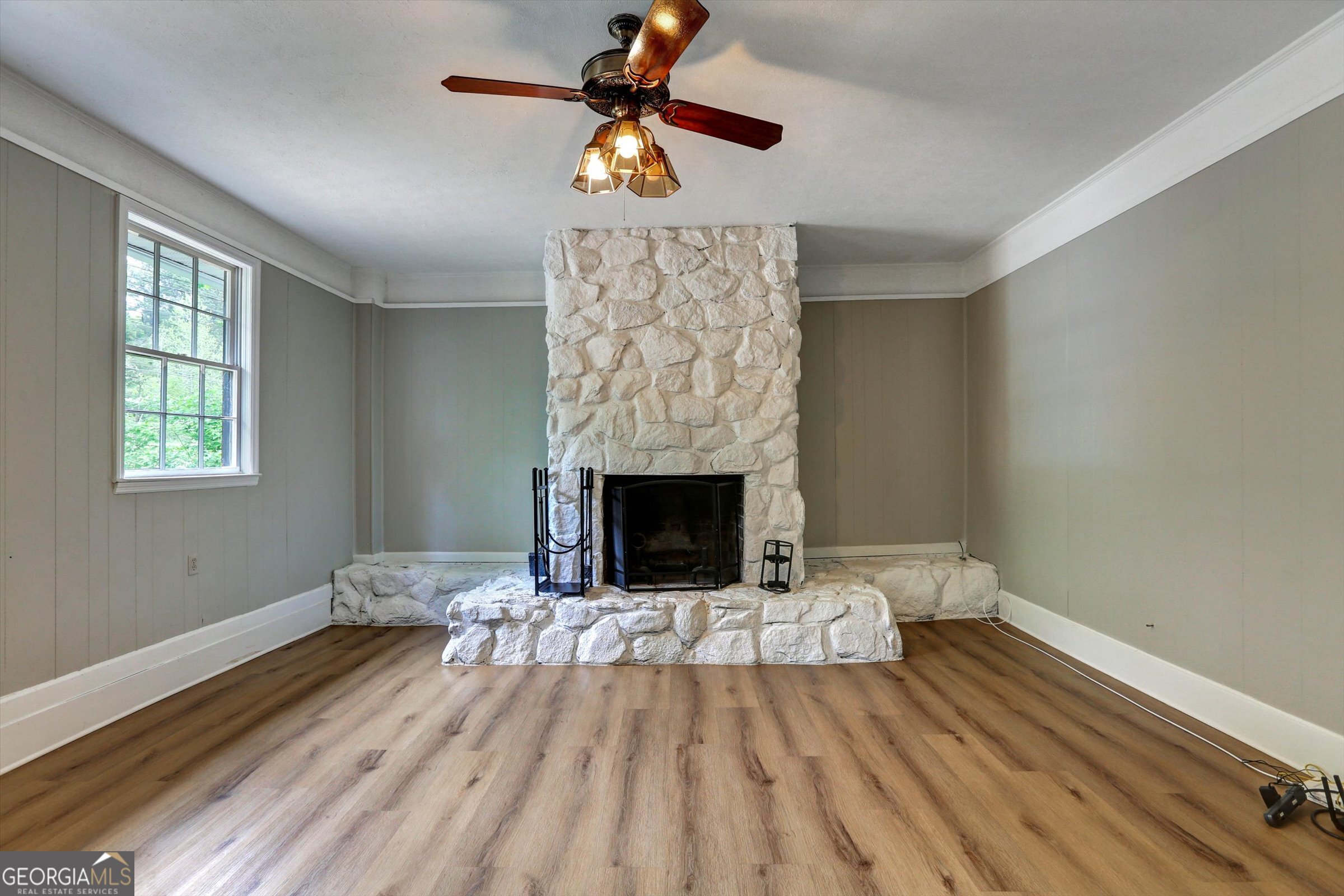 1095 Athens Road Winterville, GA 30683 - Photo 16 of 32 a view of an empty room with wooden floor a fireplace and a window