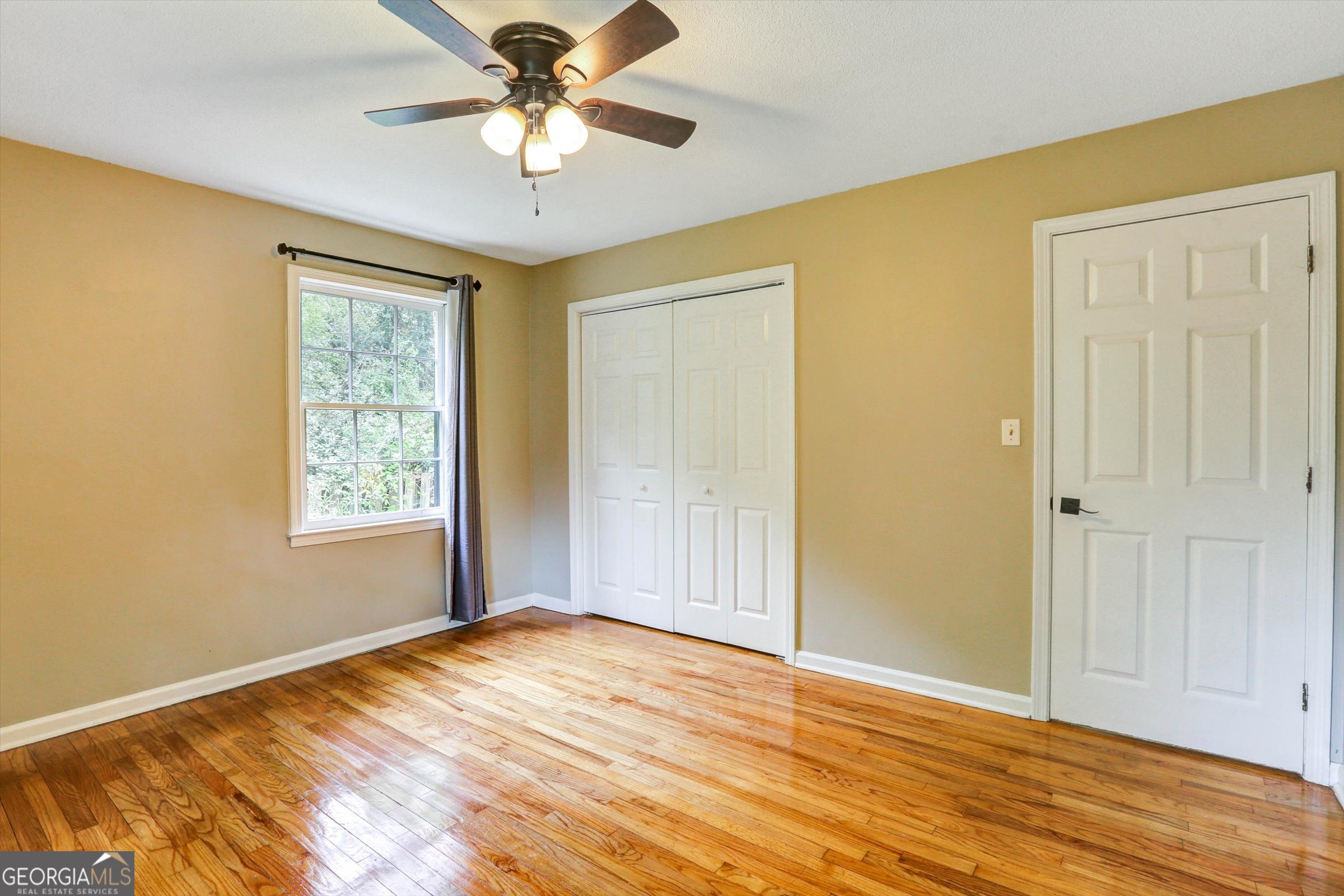 1095 Athens Road Winterville, GA 30683 - Photo 20 of 32 a view of empty room with wooden floor and fan