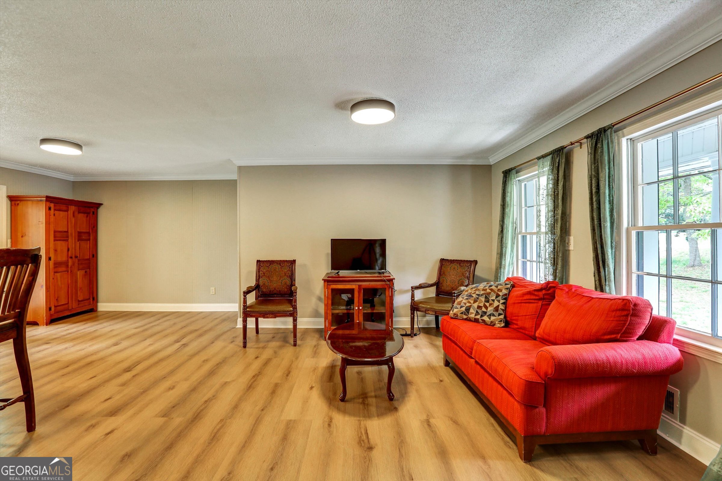 1095 Athens Road Winterville, GA 30683 - Photo 7 of 32 a living room with furniture a flat screen tv and wooden floor