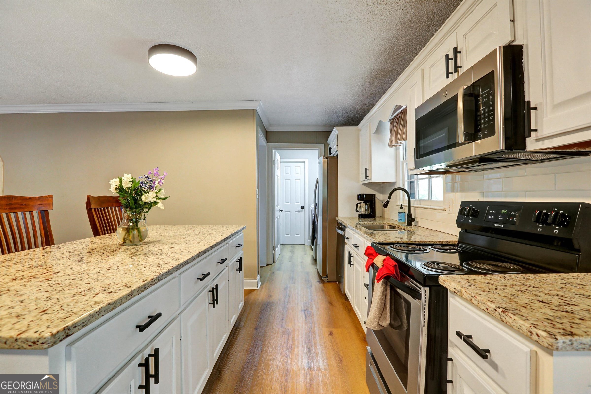 1095 Athens Road Winterville, GA 30683 - Photo 9 of 32 a kitchen with stainless steel appliances granite countertop a stove a sink and a microwave