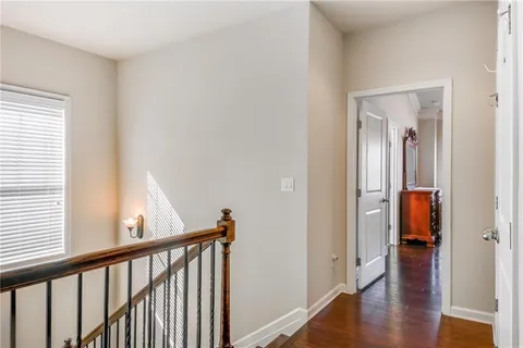a view of a hallway with wooden floor and stairs