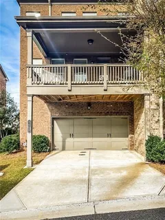 a front view of a house with large trees