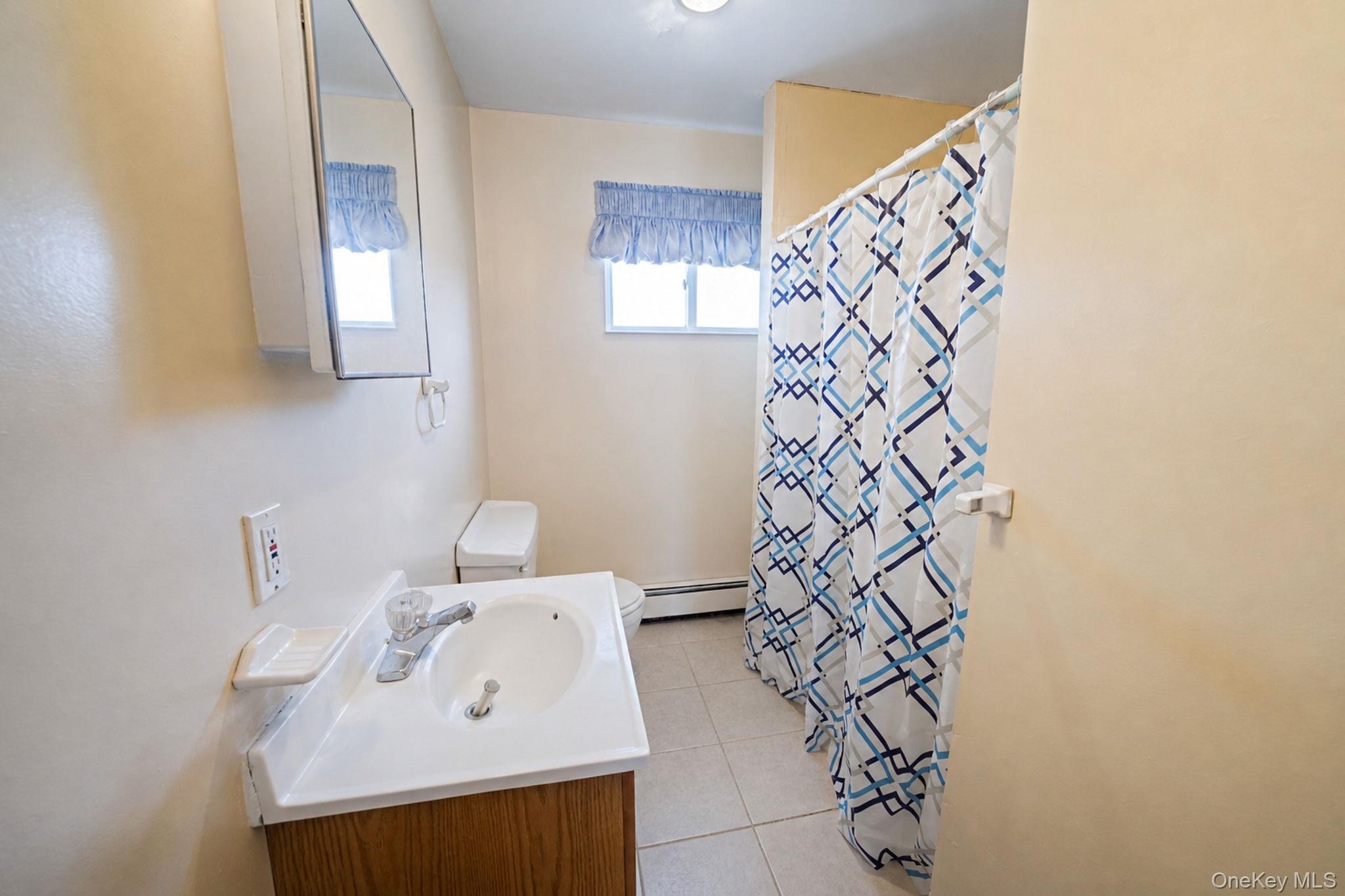 1169 Little E Neck Road West Babylon, NY 11704 - Photo 18 of 28 a bathroom with a sink a vanity and a mirror