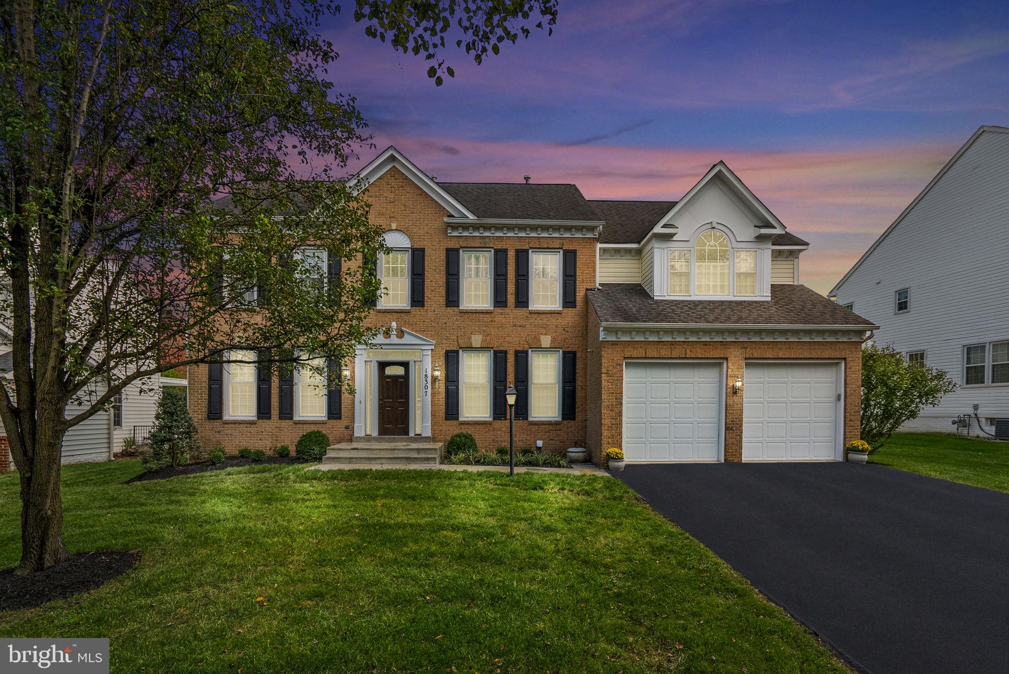a front view of a house with a yard and trees
