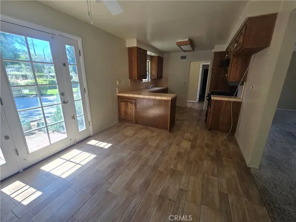 a view of a refrigerator in kitchen and dining room with wooden floor