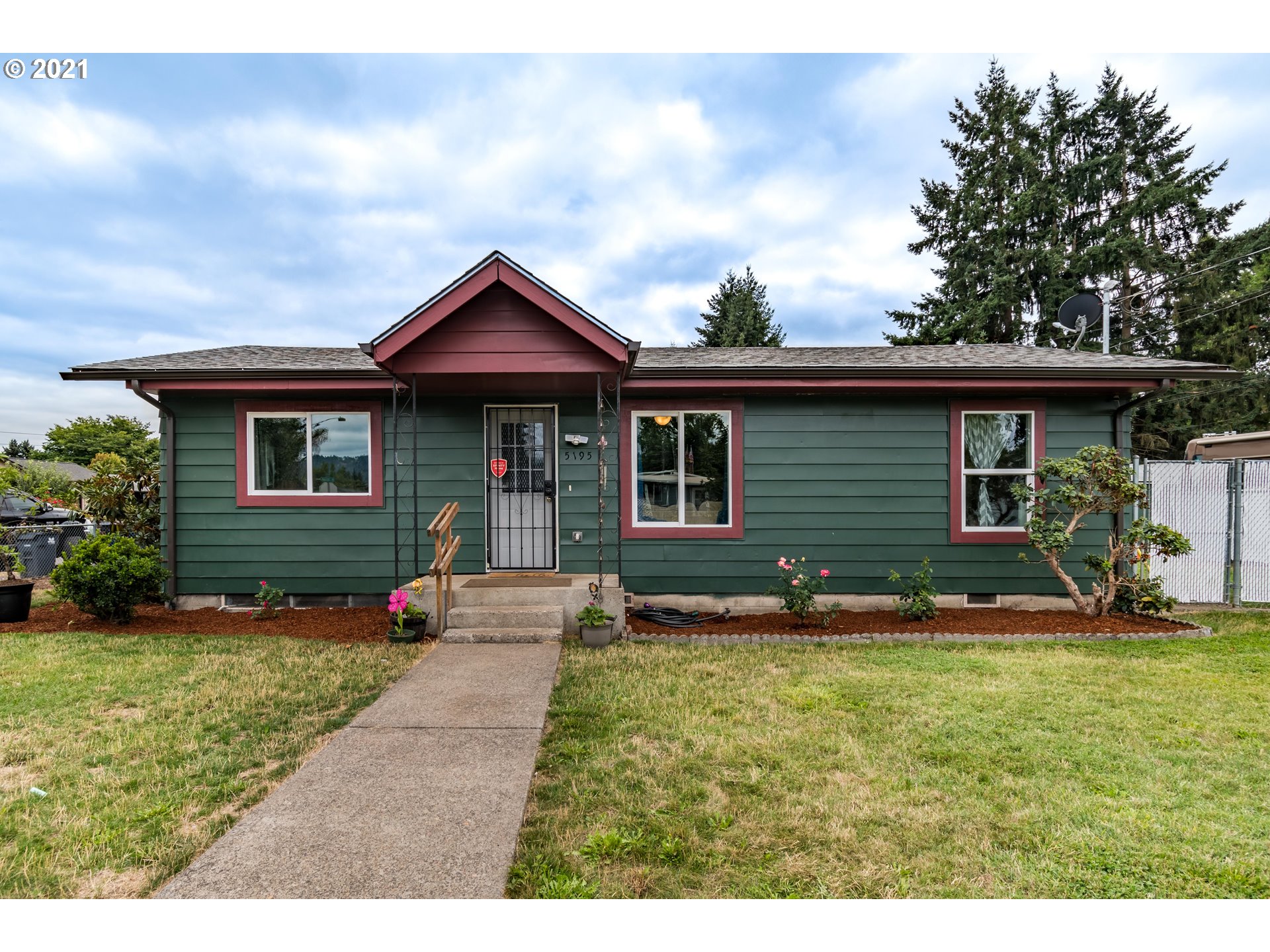a front view of a house with a yard and trees