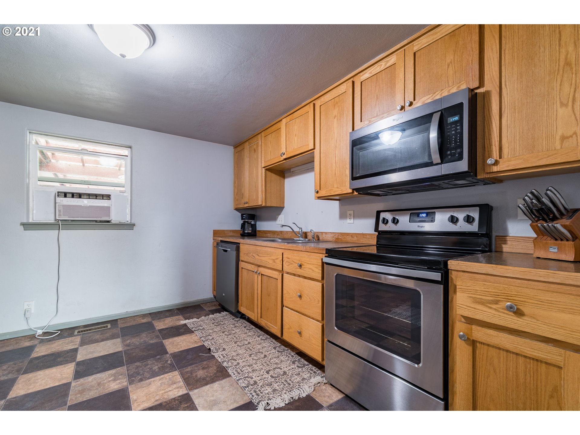 5195 E Street Springfield, OR 97478 - Photo 7 of 30 a kitchen with stainless steel appliances granite countertop a stove a microwave a sink and cabinets