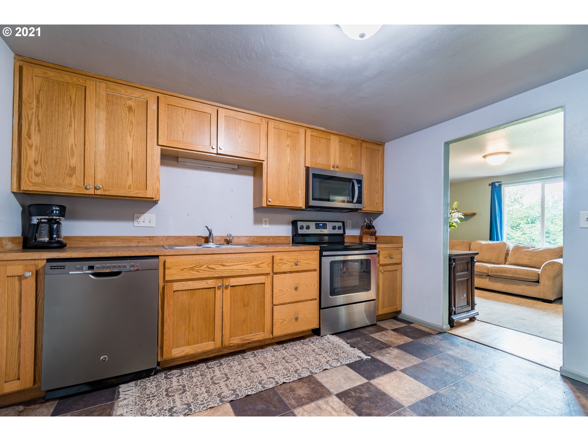 5195 E Street Springfield, OR 97478 - Photo 8 of 30 a kitchen with granite countertop a sink cabinets stainless steel appliances and a window